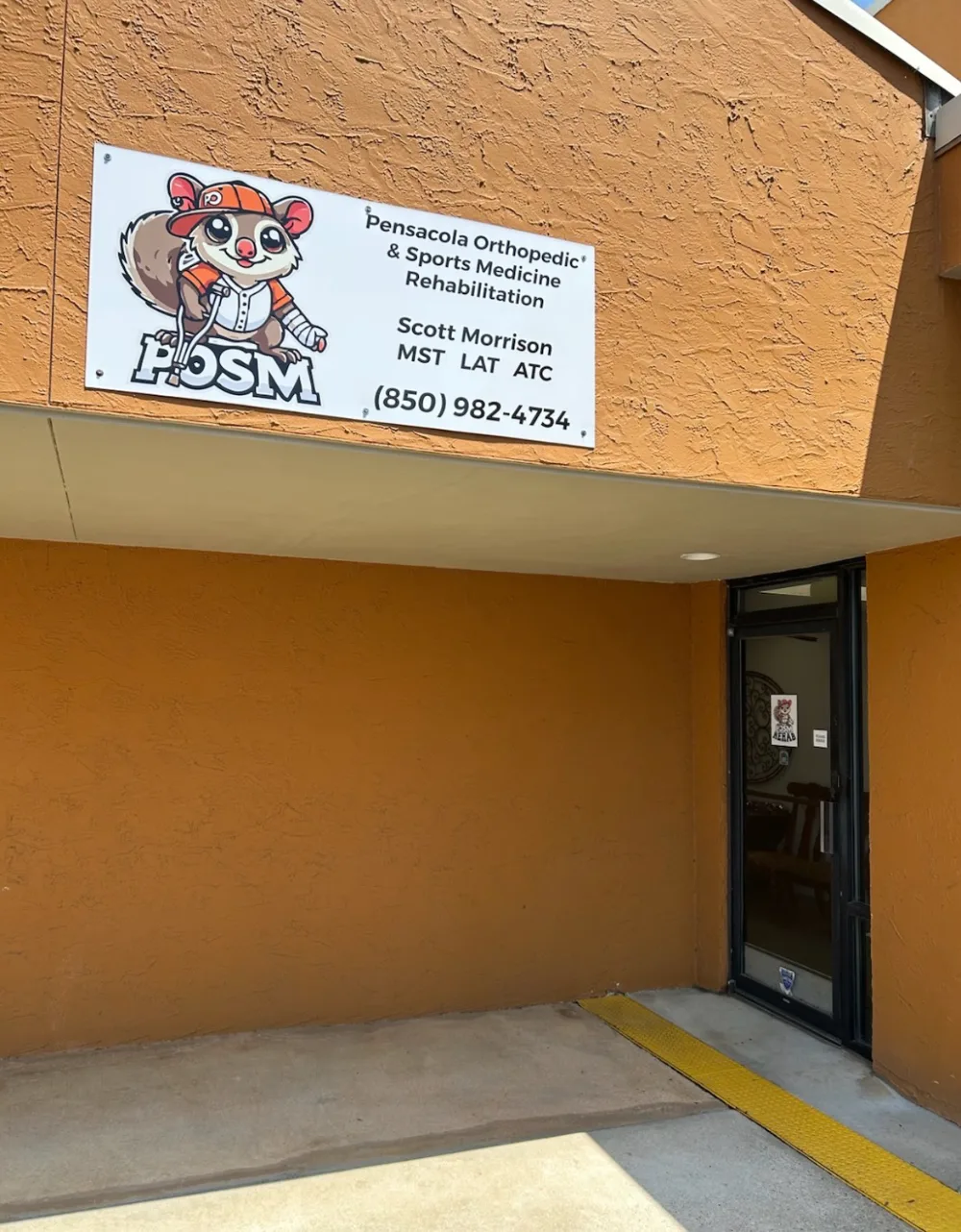 The entrance to Pensacola Orthopedic & Sports Medicine Rehabilitation, with the POSM sign above the door